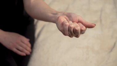 Kadın eli sıkıca kavrar ve parmaklarını açar. Dişi, el kaslarını çalıştırarak parmaklarını esnetir ve serbest bırakır. Bayan tekrar tekrar parmaklarını sıkıyor ve gevşetiyor, kol hareketliliğini arttırıyor.