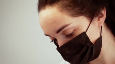 Müşteri bakımına odaklanan siyah maskeli bir stilist. Estetik merkezindeki detaylara dikkat etmek profesyonel bir iş. Tedavi sırasında profesyonel hijyen standartlarını koruyan stilist