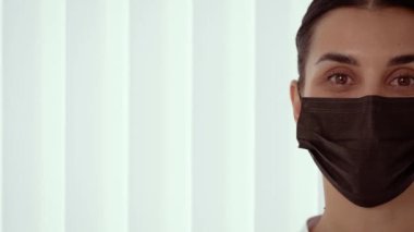 Yüz kliniğinde yüz maskesi takan bir güzellik terapisti, fotokopi alanı olan sakin bir yüz ifadesi. Yenilenme uzmanı siyah maskeli ve sakin, fotokopi alanı olan. Klinikten emin bir terapist