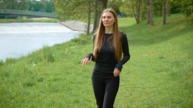 Modern müziğin ritmiyle dans eden neşeli, zayıf genç bir kadın. Mutlu kadın, çağdaş ritimlerle enerjik bir şekilde senkronize hareket ediyor. Neşeli bayan zarif bir şekilde dans ediyor.