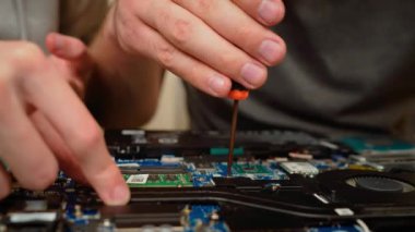 Dizüstü bilgisayardaki vidaları sıkan eller soğutma sistemini sağlamlaştırıyor. Parçaları hassasiyetle ayarlamak, sabit donanım montajını sağlamak. Dizüstü bilgisayarın iç parçaları onarılıyor, odaklanılıyor