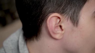 Genç oğlanın kulağını kapat. Detaylı çekim genç adam korkusu. Ergen oğlanın kulağını kapat.