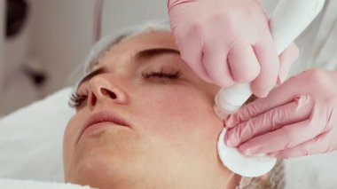 HİDRA yüz tedavisi gören hasta kadın bütünsel güzellik merkezinde. Güzellik uzmanı cildini arındırmak ve tazelemek için işlem yapıyor. Doğal ışıltıyı teşvik eden zararsız bir yöntem.