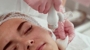 Güzellik uzmanı kadın kozmetoloji stüdyosunda su kabuğu makinesi kullanıyor. Hasta yüz temizleme tedavisi görüyor. Cildin gençleşmesine ve sulanmasına yardımcı olan tedavi