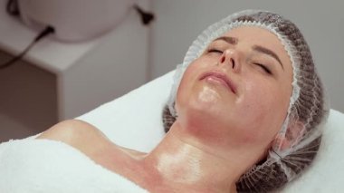 Kadın müşteri deri stüdyosunda rahatlıyor, doğal güzelliği arttırıyor. Cilt stüdyosu parlak sonuçlar için profesyonel bakım ve gençleştirme tedavilerine odaklanıyor. Kozmetik dermatoloji kliniği