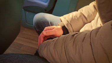 Adam modern elektrikli otobüste seyahat ederken el üstünde dinleniyor. Şehirde sakin bir otobüste rahat bir şekilde oturan bir erkek yolcu. Yolcu, şehrin elektrikli otobüsünde huzurlu bir yolculuğun tadını çıkarıyor. Erkek gezgin