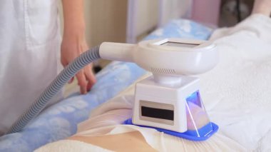 Şişman ve aşırı kilolu tedavi. Kriyoterapi. Makine kozmetolojisi. Aşırı kilolu bir kız kozmetoloji kliniğindeki yetenekli güzellik uzmanıyla kriyolipoz prosedürüne tabi tutuluyor.
