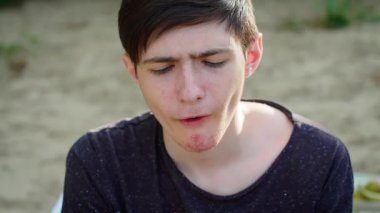 Çocuk portakal dilimi yiyor, tatlı ve narin tadını çıkarırken gözlerini kapıyor. Erkek ısıran portakal, taze ve keskin lezzetin tadını çıkarıyor. Portakal diliminden hoşlanan adam, ferahlatıcı şeylere odaklanıyor.