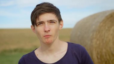 Kırsal alanda patates cipsi yiyen bir çocuk. Kırsal kesimde çıtır çıtır cipslerle atıştırıyor. Genç erkek, doğal ortamda tuzlu patates cipslerinin tadını çıkarıyor.