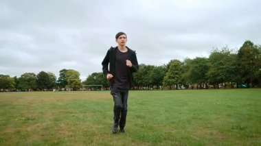 İngiltere 'deki şehir parkında çimenlik alanda koşan bir genç. İngiltere 'deki şehir parkında çimlerde koşan genç bir adam. İngiltere 'de parkta çimenler üzerinde egzersiz yapan bir çocuk. Genç erkek İngiltere 'nin çimenli bölgelerinde hareket ediyor
