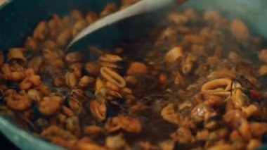 Kaynayan zengin sosla karıştırılmış deniz ürünleri. Kabaran çorbada karides, midye ve mürekkep balığı karışımı. Lezzetli bir pişirme sıvısına kabuklu deniz ürünleri karışımı atmak. Baharat için bile deniz mahsulleri karışımı.