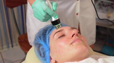 Ameliyat değil, donanım kozmetolojisi, yaş gençleştirme karşıtı cilt bakımı konsepti. Güzel bir kadın kozmetoloji kliniğinde yüz gerdirme ameliyatı oluyor. Güzellik tedavi konsepti