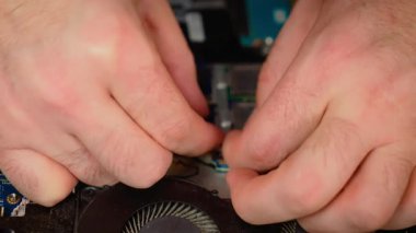 Güç kablosu laptopa bağlanırken soğutma sistemi kuruluyor. Pervane modülü takılıyor ve bakım sırasında konnektör takılıyor. Soğutma ünitesi güvene alınıyor ve sistem montajı için kablolar yeniden bağlanıyor
