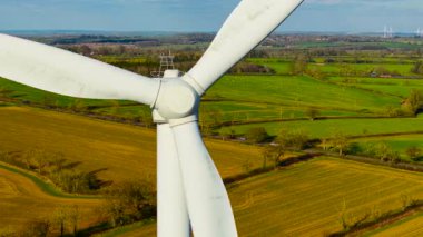 Rüzgar çiftliği yeşil enerji üretiyor. Rüzgar türbini yeşil elektrik üretmek için güçlü döner pervaneler üretir. Dönen ağır bıçaklar rüzgar çiftliğinde çevre dostu güç üretiyor.