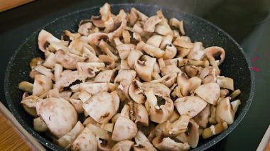 Akşam yemeği hazırlıkları sırasında Skillet 'te taze mantarlar. Mutfakta yemek pişirmek, yemek pişirmek ve ocakta tava pişirmek. Lezzetli, sağlıklı vegan ya da vejetaryen yemekleri pişirmek