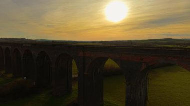 Göz kamaştırıcı viyadük köprüsünden yansıyan gün batımı gibi düşün. Gün batımında yukarıdan çekilen güzel vadi ve eski demiryolu viyameti. Ünlü simgeler, tarihi bölge, yemyeşil yoluyla ulaşım sistemi.