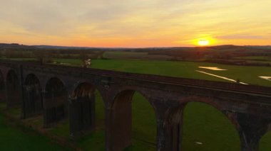Günün son ışığında manzaranın üzerinde viyadük gökdelenler yükseliyor. Tren viyadük üzerinde gün batımı canlı, doğal manzara, gökyüzünden yakalandı. Ünlü konum, ünlü bölge, ulaşım sistemi