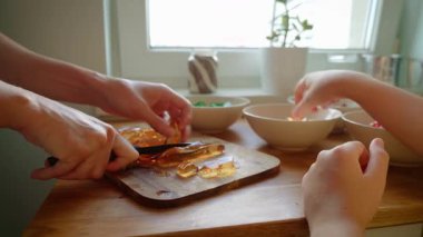 Tahtada bıçakla jöle doğrayan eller. Tatlı hazırlığı için renkli jelatinleri küçük parçalara ayırıyorum. Pasta dekorasyonu için reçel küpleri hazırlanıyor