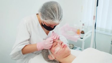 Kadın hassas dermatolojik aletlerle ergenlik sivilcelerini çıkarıyor. Kadın temizliğe ve deri dokusunu geliştirmeye odaklanıyor. Profesyonel akne tedavisi gören kız cilt temizliğini geliştiriyor