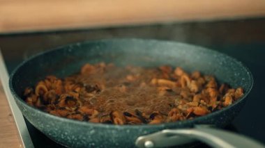 Lezzetli çorbanın içinde deniz ürünleri karışımı kaynıyor. Kabaran midyeler, karides ve zengin soslu mürekkep balığı. Tadını arttırmak için yavaş pişirilmiş kabuklu deniz ürünleri karışımı. Hafif sıcaklıkta deniz ürünlerine derin umami aşılamak.