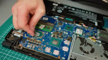Laptop ana kartındaki işlemci çipinin termal macununu temizliyorum. Bakım için kurumuş bileşiği işlemci yüzeyinden çıkarıyorum. Taze macun için termal kalıntıları temizleyerek işlemci hazırlanıyor