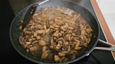 Öğleden Sonra İyi-Edebiyat Mutfağı 'nda Mantar Sobası' nda karıştırmak. Yağ ve tereyağı karışımı ile cızırtılı tavada kavrulmuş şampiyonlar, spatulayla hafifçe karıştırılıyor. Lezzetli ve besleyici hazırlanıyor