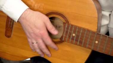 Kapalı mekandaki gündelik müzik sırasında el tıngırdatma klasik akustik gitar. Rahatlamış iç mekanlarda geleneksel altı telli çalgıların tellerini koparan parmaklar. Sıcak iç atmosferde ahşap akustik gitarda melodi çalan eller.