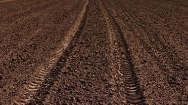 İlkbahar tarım çalışmaları sırasında traktör izleri sahada. Ekin yetiştirmek için toprağı işleyerek tarlayı hazırlıyorum. Araziyi tarımsal büyümeye hazırlayan makineler