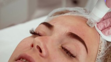 Hasta kadın kozmetoloji stüdyosunda hidroterapi tedavisi sırasında dinleniyor. Güzellik uzmanı derin cilt temizleme ve sıvı alma için gelişmiş makineyi dikkatlice uyguluyor. Cilt bakımı uzmanı parlayan ve tazelenmiş cilt için profesyonel yüz bakımı yapıyor.