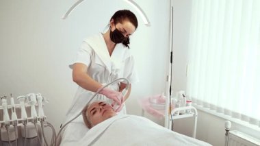 Kozmetik uzmanı cilt atölyesinde işlem sırasında su mikro dermabrüksiyon cihazı kullanıyor. Daha pürüzsüz bir cilt için deri soyma ve sıvı alma üzerine odaklanan kadın bir uzman. Bayan Güzellik Uzmanı yenilenmiş ve ışıl ışıl bir görünüme sahip
