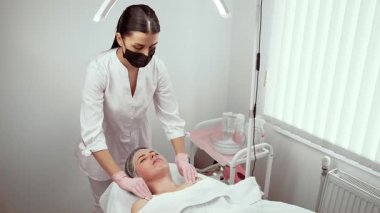 Güzellik kliniğindeki profesyonel prosedür kadın müşterinin rahatlamasını sağlıyor. Cilt bakımı uzmanı cilt sağlığını ve dokusunu iyileştiriyor. Genel olarak ışıltıyı teşvik eden oturum sırasında gençleşme ve sağlığa odaklanan terapist