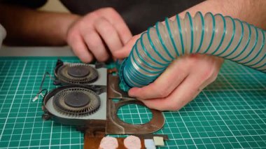 Toz temizleme için süpürge kullanarak laptop soğutma sistemi temizliyorum. Enkazı temizlemek ve hava akışını iyileştirmek için fan modülü boşaltılıyor. Vakum tüpüyle toprağı emerek soğutma ünitesini korumak