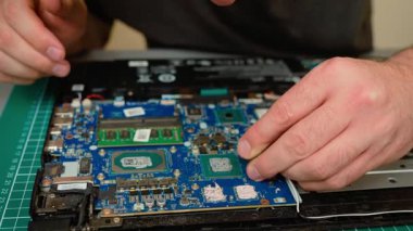 Laptop ana kartındaki grafik çipinden eski termal macunları temizliyorum. Bakım için GPU yüzeyinden kurutulmuş bileşik çıkarılıyor. Yeni yapıştırıcı uygulaması için termal kalıntı temizleyerek çip hazırlanıyor