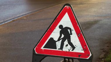 Birleşik Krallık 'ta yol yapım uyarısı. Trafik danışma kurulu İngiltere 'de bakım işi olduğunu belirtiyor. Yol tehlikesi işareti İngiltere 'de onarım bölgesini gösteriyor
