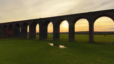 Manzaralı demiryolu köprüsü gün batımında gölgede kalıyor. Viyadük demiryolu, etrafındaki inanılmaz vadi ve doğal güzelliklerle dolu. Ünlü tarihi mekan, ikonik bölge, güzel doğada ulaşım yolu.