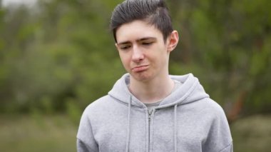 Üzüntü ve üzüntü içinde suratını buruşturan kederli ergen çocuk. Hüzün ve keder içinde dudaklarını büken melankolik genç adam. Acılı bir ifadeyle, derin bir üzüntü gösteren çökmüş bir ergen.