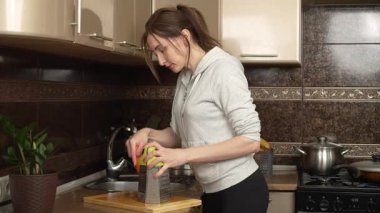 Mutfakta havuç rendeleyen mutlu kadın. Mutfakta havuç parçalamak için daha büyük şeyler kullanan gülen kadın. Neşeli dişi yemek hazırlarken havuç rendeliyor.