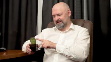 Kel ev sahibi kaktüse dokunuyor ve iğne oluyor. Evde kel bir girişimci kaktüs dürtüyor ve dikenleri tutuyor. Kel adam eve koşuyor kaktüslere dokunuyor ve dikenleri tarafından incitiliyor.