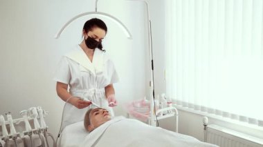 Dermatoloji ofisinde cilt spatulası kullanan kozmetolog güzellik uzmanı. Dişi uzmanlar cilt bakımı ve gözenek temizliği yapıyor. Bayan Güzellik Uzmanı müşteri için derin temizlik ve cilt yenilemeye odaklanıyor