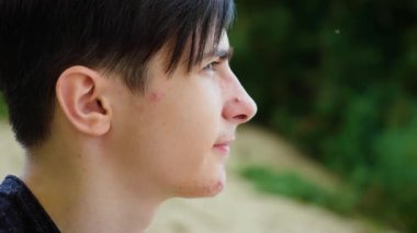 Ahududu yiyen çocuk, tatlı tatların ve odaklanmış ifadenin tadını çıkarıyor. Erkek, ahududu tadıyor, sulu ve taze hislerin tadını çıkarıyor. Ahududu yiyen, doğal ve keskin tadı olan bir adam.