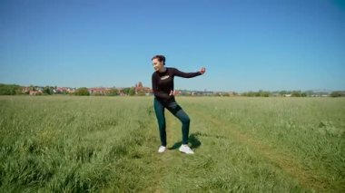 Çimenlik alanda hayali gitar çalıyormuş gibi yapan bir kadın, coşkuyla rock yıldızı kılığında. Dişi, kendinden emin ve yetenekli enerjik kaya hareketlerini taklit ediyor. Yaratıcılığı ve eğlenceyi ifade eden kadın, müzisyenin ruhunu neşeli bir şekilde somutlaştırıyor.