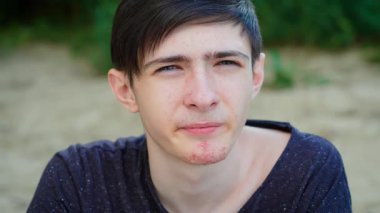 Genç bir delikanlı yaban mersini yiyor, tatlı ve odaklanmış ifadenin tadını çıkarıyor. Yaban mersini tatma, taze ve sulu hislerin tadını çıkarma. Yaban mersini yiyen, doğal ve lezzetli tadı olan adam.