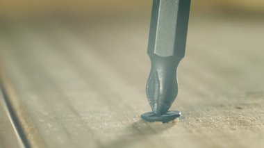 Kapalı çekimde siyah kendini beceren vida ahşap tahtadan teker teker çıkıyor. Macro Viraj İnşaat Hızlandırıcısı keresteden tamirciye dönüşüyor. Keskin metal vida tadilat sırasında gevşetiyor.