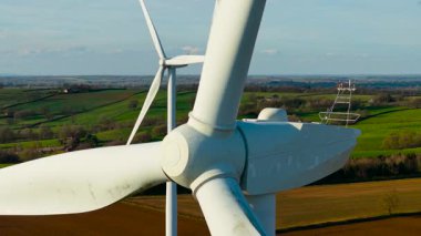 Büyük rüzgar türbinlerinin temiz sürdürülebilir enerji üreten sinematik hava görüntüsü. Sürdürülebilir güç üretmek için dönen türbin bıçakları. Dönen uzun bıçaklar rüzgâr çiftliğinde sürdürülebilir enerji üretiyor.