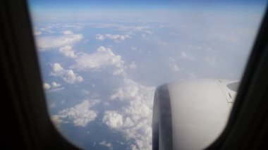 Açık Gün 'deki Uçuş sırasında Hava Görüntüsü Kabarık Bulutlar ve Uçak Motoru. Uçak penceresinden bakıldığında yumuşak beyaz bulutlar görünür