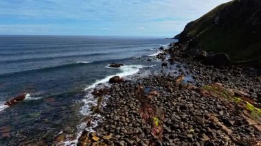 Dalgalar İskoçya 'da Kuzey Denizi' nin kayalık kıyılarına vuruyor. Dalgalar kıyı manzarası boyunca kayalara çarpıyor. Uçsuz bucaksız kayalıklarda dalgalar yükseliyor.