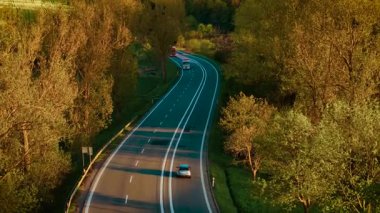 Gün batımında kırsal otoyolda kamyon şoförlüğü yapmak ve nakliye araçlarıyla mal teslimatı yapmak. Taşra yolu boyunca yük taşıma araçları kullanıyormuş. Manzaralı şehirlerarası güzergah üzerinden mal taşıma