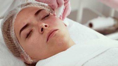 Gelişmiş estetik atölyesinde su kabuğu soyma cihazı tedavisi gören hasta kadın. Güzellik uzmanı derin cilt temizleme ve susuzluk için prosedür uyguluyor. Cilt dokusunu ve görünümünü geliştiren yumuşak deri yüzme metodu