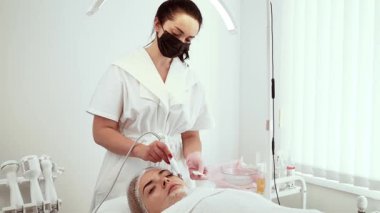 Kozmetik uzmanı, kaplıcadaki işlem sırasında ultrasonik deri dökücü kullanıyor. Cilt bakımı ve deri yenileme tedavisine odaklanan kadın bir uzman. Bayan güzellik uzmanı pürüzsüz ve parlak cilde gelişmiş bakım sağlıyor.