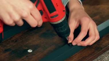 Mobilya montajı yapan adam, masa ya da güvenli gardırop, tornavida kullanıyor. El sanatları ustası ev detaylarını cilalıyor. Hizmet veya yeniden kalibre çalışması yapılıyor